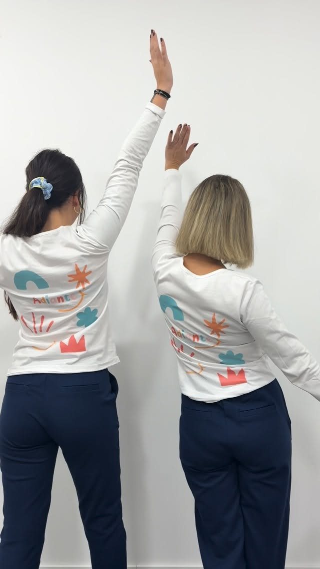 Dos profesionales de espaldas con las camisetas de Adiante